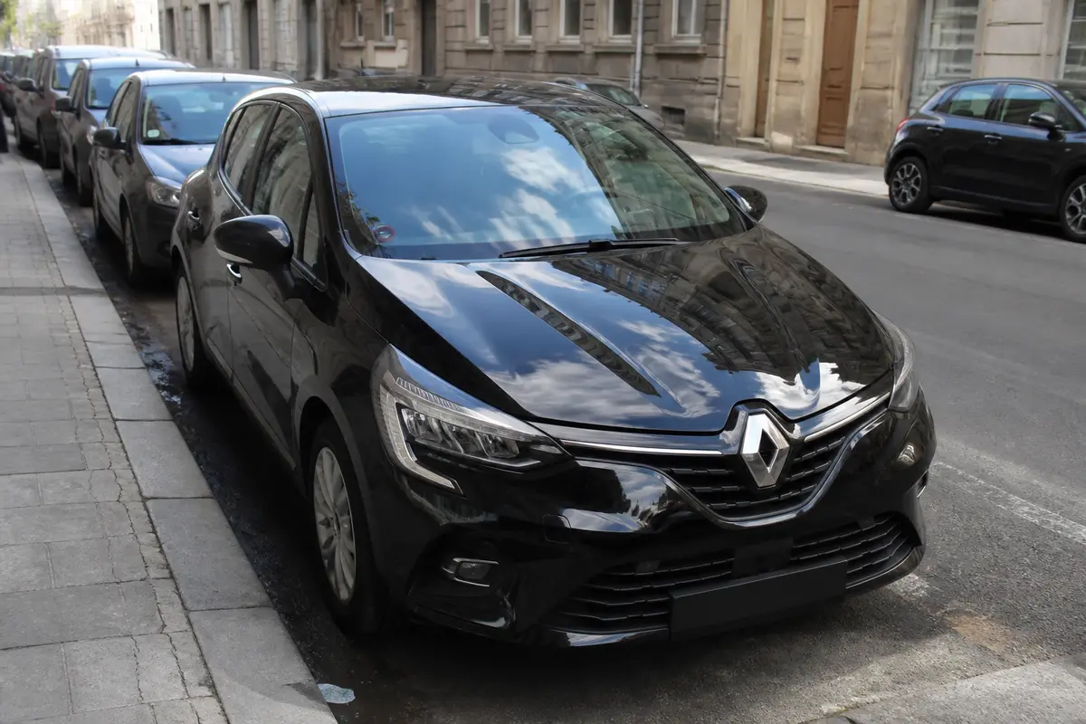 Voiture noire Renault stationnée en ville avec assurance location voiture via carte Gold
