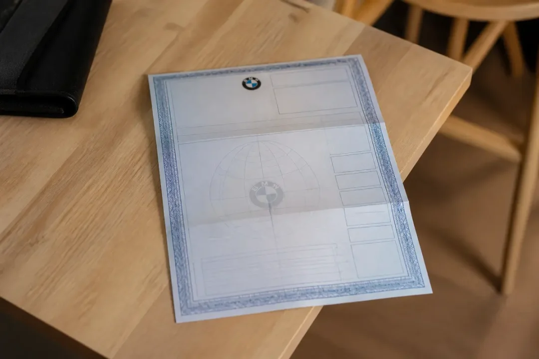 Document officiel BMW sur une table incluant un certificat de conformité pour BMW