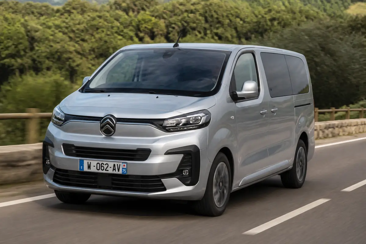 Voiture Citroën grise roulant sur route bordée d'arbres adaptée pour Jumpy 5 places