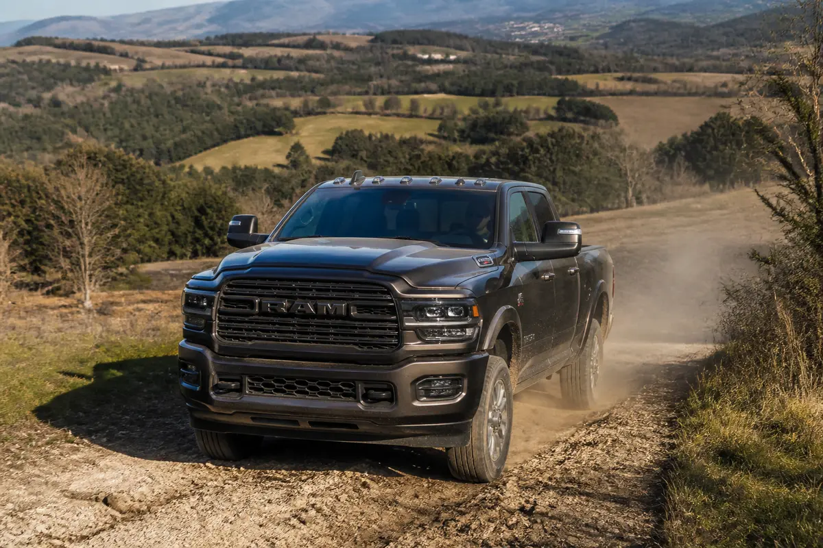 Vue avant du pick up Ram 2500 noir sur chemin de terre en montagne