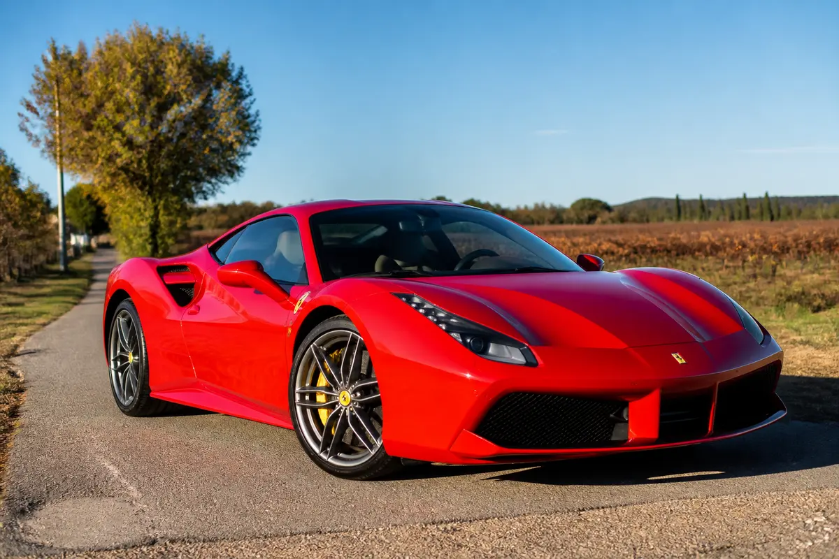 Ferrari rouge sur route de campagne, symbolisant le prix d'une Ferrari.