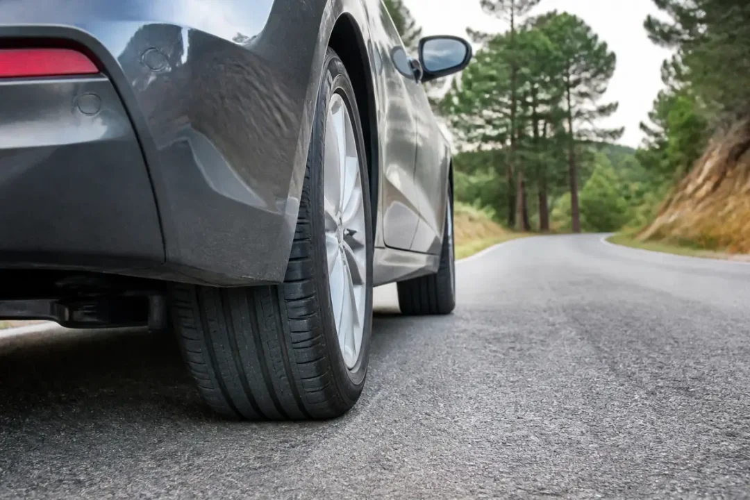 Vue arrière d'une voiture sur route, illustrant l'indice de vitesse du pneu H ou V